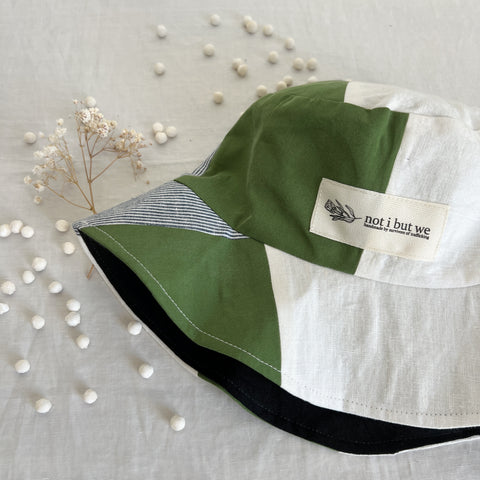 Bucket hat with brand logo and green, white, and blue linen patches.
