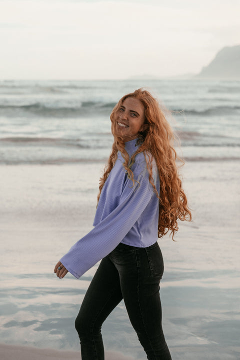 A smiling woman wearing the thistle crop sweater