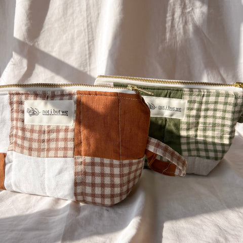 Two patchwork pouches with visible branding on a white fabric background