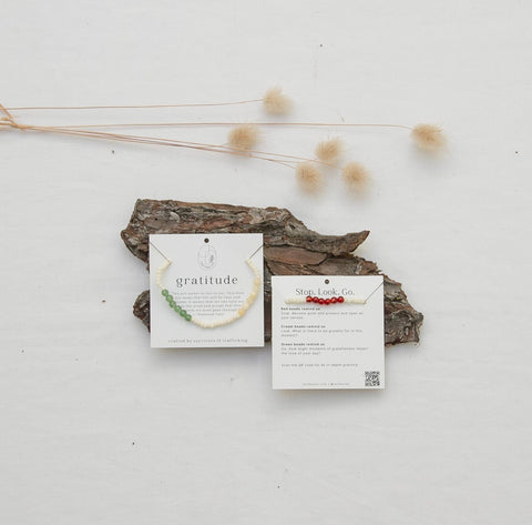 Product Packaging with gratitude practice stop-look-go at the back.