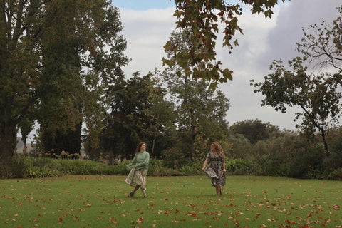 women twirling in sisterhood dress in a field