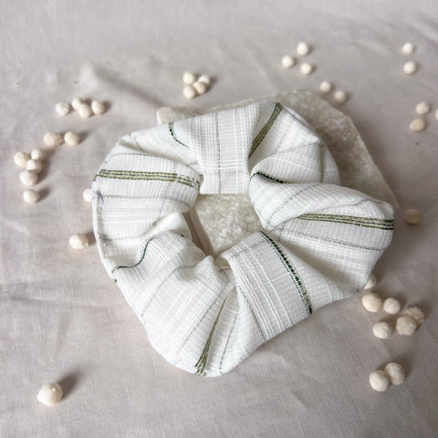 White scrunchie with green stripes on a light gray background