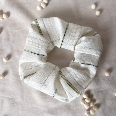 White scrunchie with green stripes on a light gray background