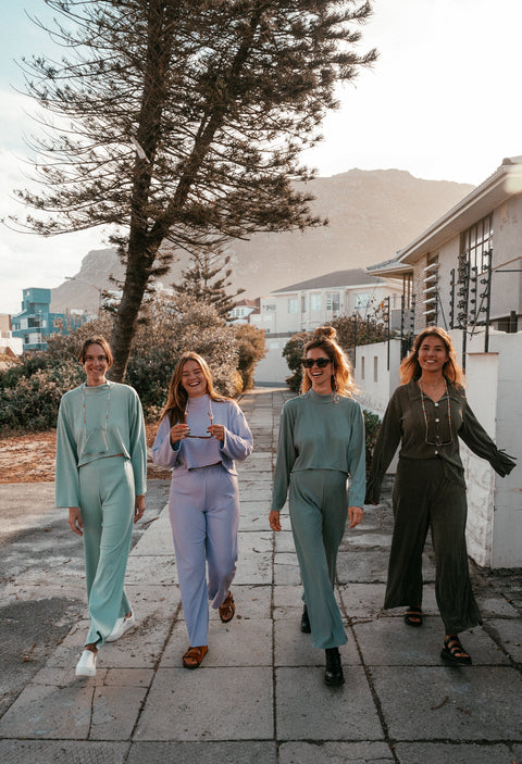 Models wearing the aw24 clothing collection in Muizenberg's streets.