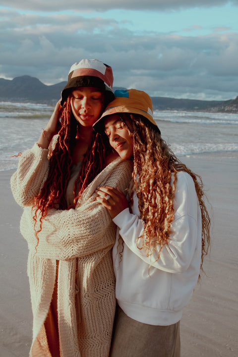 Two models wearing Not I But We's Patchwork Bucket Hats