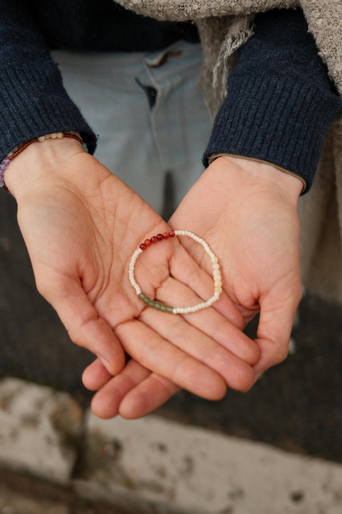 The gratitude bracelet with green, red, and white beads.