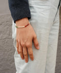 Gratitude Bracelet worn by a woman in a blue sweater.