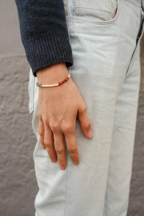 Gratitude Bracelet worn by a woman in a blue sweater.