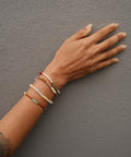 Not I But We's Mindful bracelets worn by a woman with a tattoo.