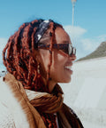 A woman smiling while wearing Not I But We's headband