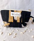 Patchwork pouch with a visible brand label on a light background