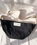 Black bag with a visible brand label on a white fabric background