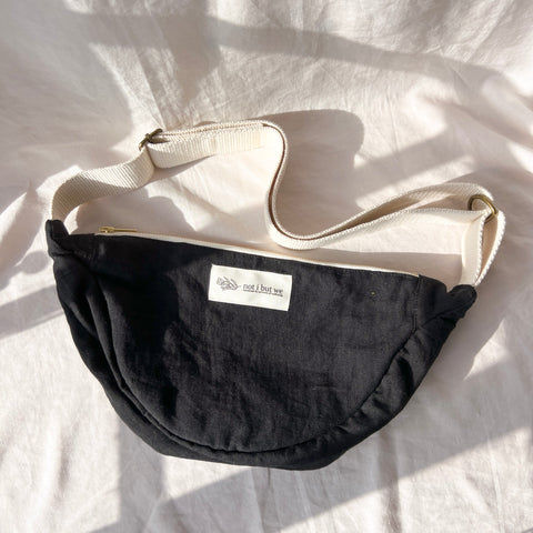 Black bag with a visible brand label on a white fabric background
