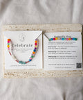 Colorful beaded bracelet on a card with text and QR code on a textured surface