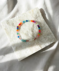 Colorful beaded bracelet on a white stone surface