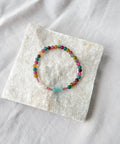 Multicolored beaded bracelet on a white stone surface