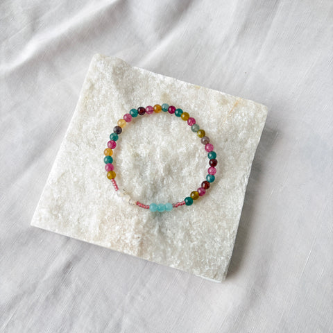 Multicolored beaded bracelet on a white stone surface