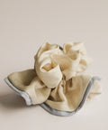 Beige scrunchie with gray trim on a beige background
