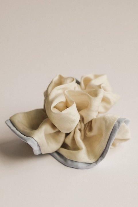 Beige scrunchie with gray trim on a beige background