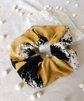 Scrunchie with black and white abstract pattern on a light background