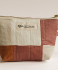 Patchwork pouch with a visible brand label on a light background