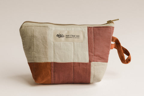 Patchwork pouch with a visible brand label on a light background