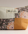 Patchwork pouch with floral patterns and a visible brand label on a neutral background