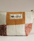 Patchwork pouch with a visible brand label on a neutral background
