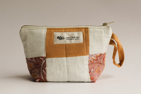 Patchwork pouch with a visible brand label on a neutral background