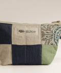 Patchwork pouch with embroidered design on a beige background