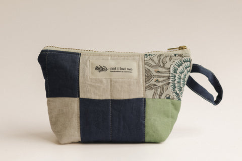 Patchwork pouch with embroidered design on a beige background