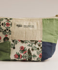 Fabric pouch with floral pattern and visible brand label on a plain background