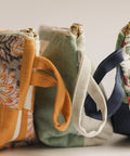 Four fabric pouches with floral and plain designs on a light background