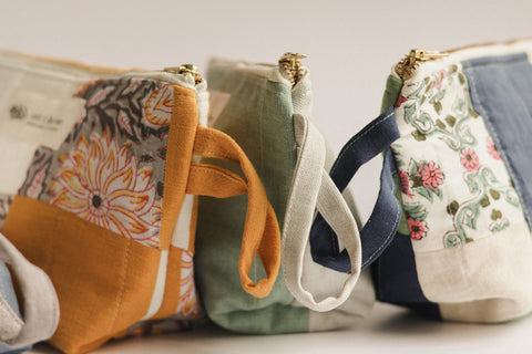 Four fabric pouches with floral and plain designs on a light background