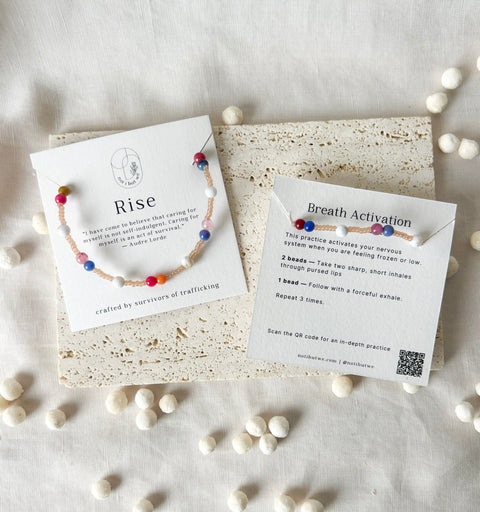Colorful beaded bracelet with cards on a textured surface