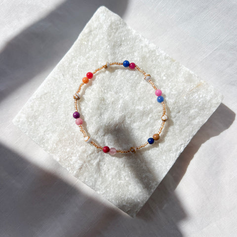 Multicolored beaded bracelet on a textured white surface