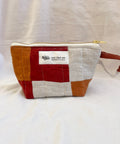 Patchwork pouch with a visible brand label on a white background
