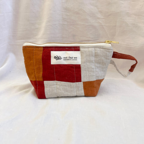 Patchwork pouch with a visible brand label on a white background