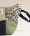 Fabric pouch with floral pattern and handle on a white background
