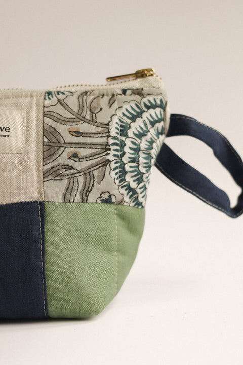 Fabric pouch with floral pattern and handle on a white background