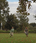 women twirling in sisterhood dress in a field