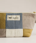 Patchwork pouch with a visible brand label on a light background