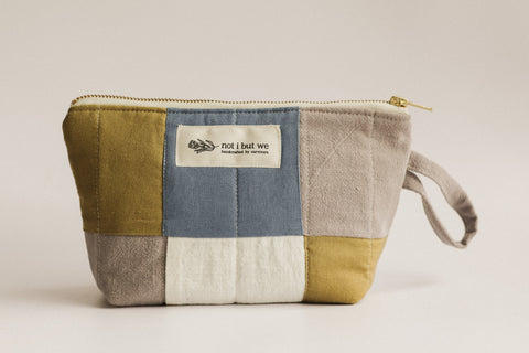 Patchwork pouch with a visible brand label on a light background