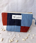 Patchwork pouch with a visible brand label on a light fabric background