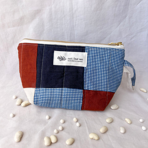 Patchwork pouch with a visible brand label on a light fabric background