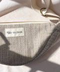 Gray bag with a 'not i but we' label on a light background